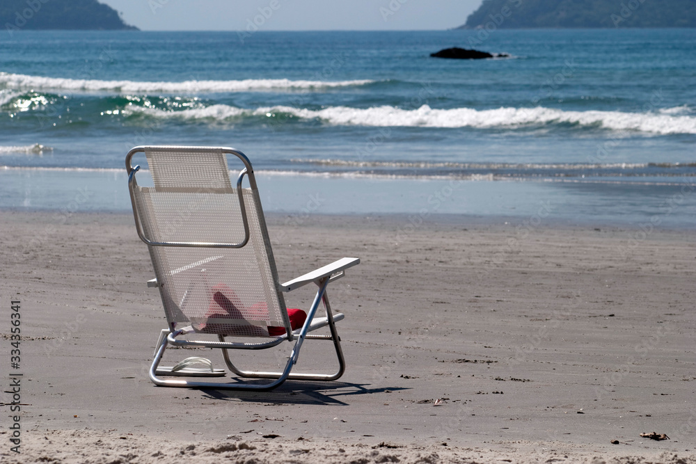 White beach chair abandoned in the sand White beach chair abandoned in the sand