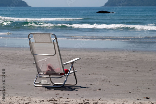 White beach chair abandoned in the sand © Tacito