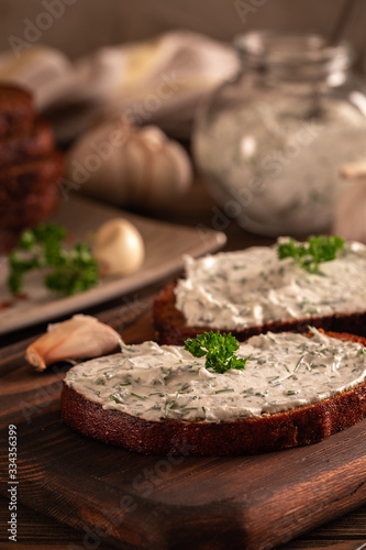 Black bread croutons with garlic and herbs with sauce on a wooden table