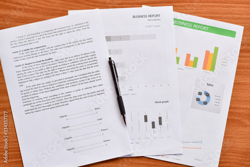 Top view of paper, graphs and charts about business placed on the table