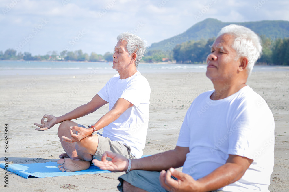 Two elderly men exercise At the beach by the sea in the morning Have a happy life after retirement. Concepts of older communities and health care. Two elderly men exercise At the beach by the sea in the morning Have a happy life after retirement. Concepts of older communities and health care.