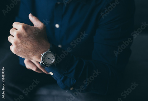 looking at luxury watch on hand check the time at workplace.concept for managing time organization working,punctuality,appointment.fashionable wearing stylish © panitan