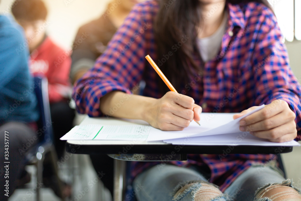 high school,university student study.hands holding pencil writing paper answer sheet.sitting lecture chair taking final exam attending in examination classroom.concept scholarship for education abroad high school,university student study.hands holding pencil writing paper answer sheet.sitting lecture chair taking final exam attending in examination classroom.concept scholarship for education abroad