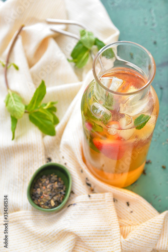 Jug of tasty cold tea on table