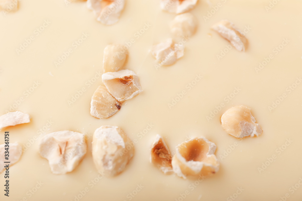 Sweet white chocolate with nuts as background, closeup