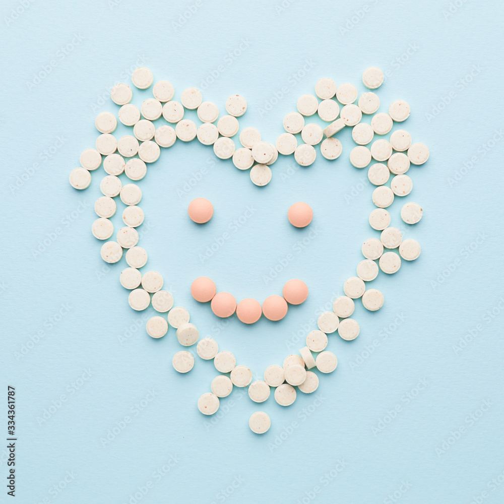 Human heart and smile made of pills on color background Human heart and smile made of pills on color background