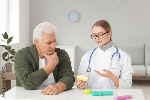 Doctor giving pills to patient in clinic © Pixel-Shot