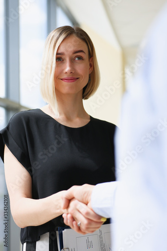 Businesswoman and woman shake hands as hello in office portrait. Friend welcome introduction greet or thanks gesture product advertisement partnership approval arm strike bargain on deal concept