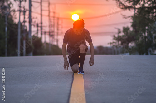 Runner man sitting on road to start running