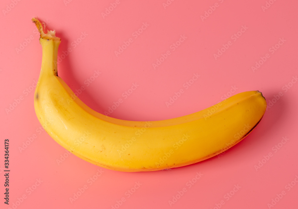 Banana is isolated on a pink background.
