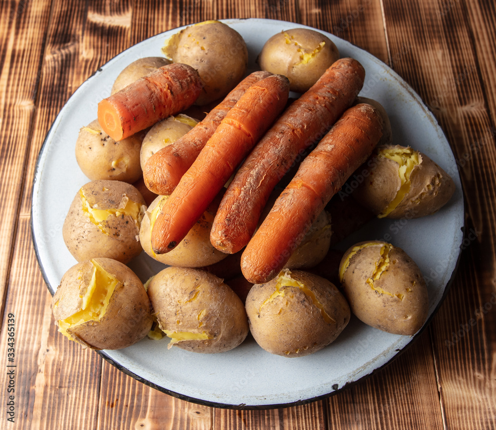 Boiled potatoes and carrots on a wooden . Boiled potatoes and carrots on a wooden .