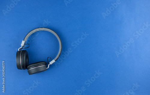 Top view black headphones on blue background