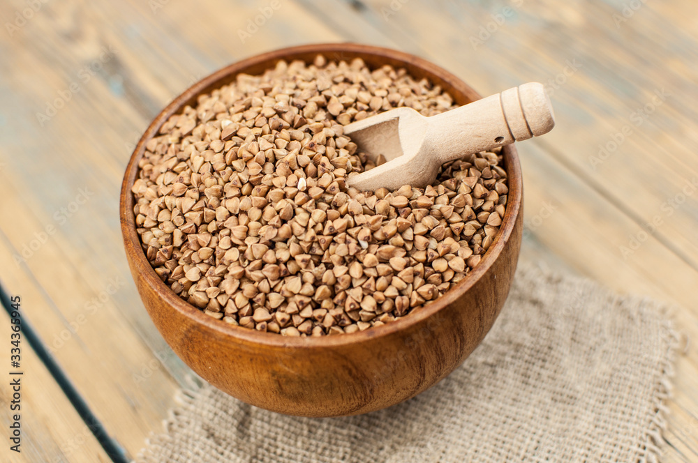 Buckwheat in bowl on table, spoons, top view Buckwheat in bowl on table, spoons, top view