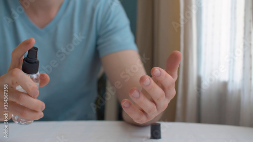 Man spraying sanitaizer on his hands photo