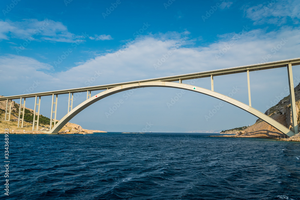 Bridge to the island Krk under blue sky on a sunny summer day. Krk is the big island of the Croatian coast of the Adriatic Sea. Travel landscape