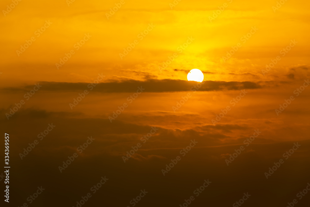 Closeup of beautiful sun floating between the clouds in morning.