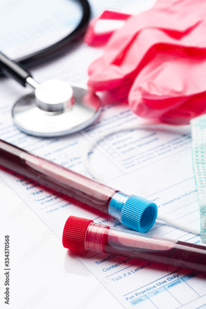 Laboratory Testing Patient’s Blood Samples for Presence of Coronavirus (COVID-19). Test Tube Containing a Blood Sample on Doctor Table Laboratory Testing Patient’s Blood Samples for Presence of Coronavirus (COVID-19). Test Tube Containing a Blood Sample on Doctor Table
