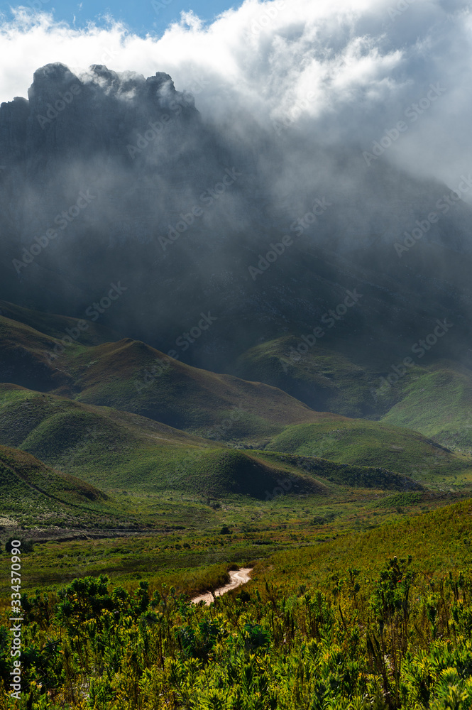 The mountains of Jonkershoek near Stellenbosch South Africa with mist swirling around the mountain tops above the valley