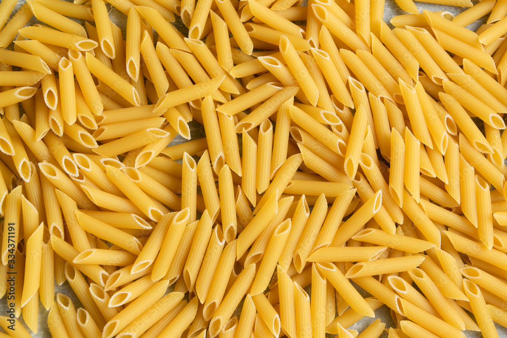 Food background - dry penne pasta, whole wheat uncooked ingredient Food background - dry penne pasta, whole wheat uncooked ingredient