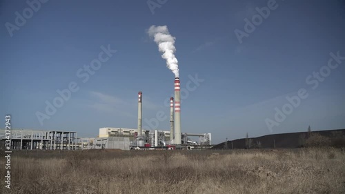 Power plant producing smoke during sunny day