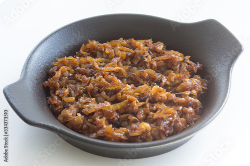 Photos Close up caramelized onion on black plate on the white background
