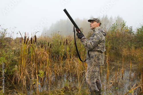 the hunter with a gun prepared to shoot the ducks