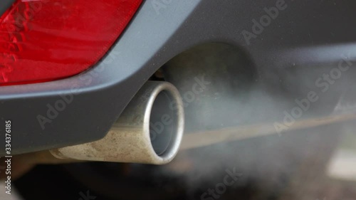 Smoke emissions fumes from car exhaust tailpipe causing air pollution and smog photo