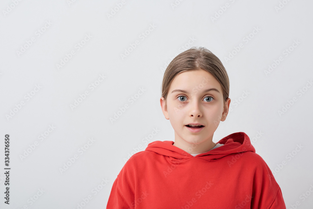 Scared or surprised teenage girl in red hoodie standing in front of camera Scared or surprised teenage girl in red hoodie standing in front of camera