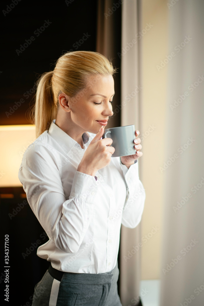 Young beautiful woman enjoying in coffee.Businesswoman working from a hotel room. Young beautiful woman enjoying in coffee.Businesswoman working from a hotel room.