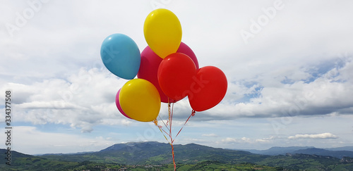 Colorful balloons on the background of the sky and landscape of San Marino. Panoramic view.