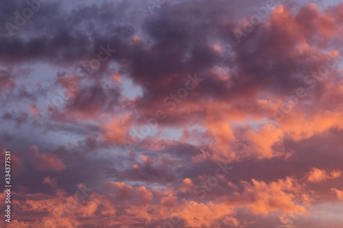 Idyllic sunshine sky with golden, purple and pink clouds in blue sky as abstract texture, background. © finepoints