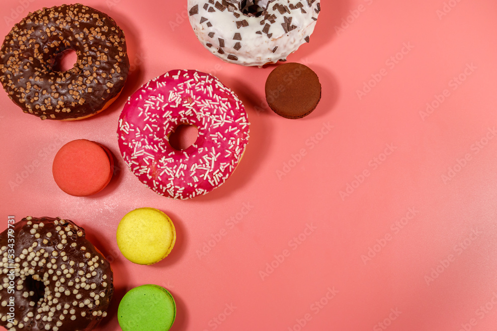 Tasty donuts and macaroons on pink background. Top view, copy space Tasty donuts and macaroons on pink background. Top view, copy space
