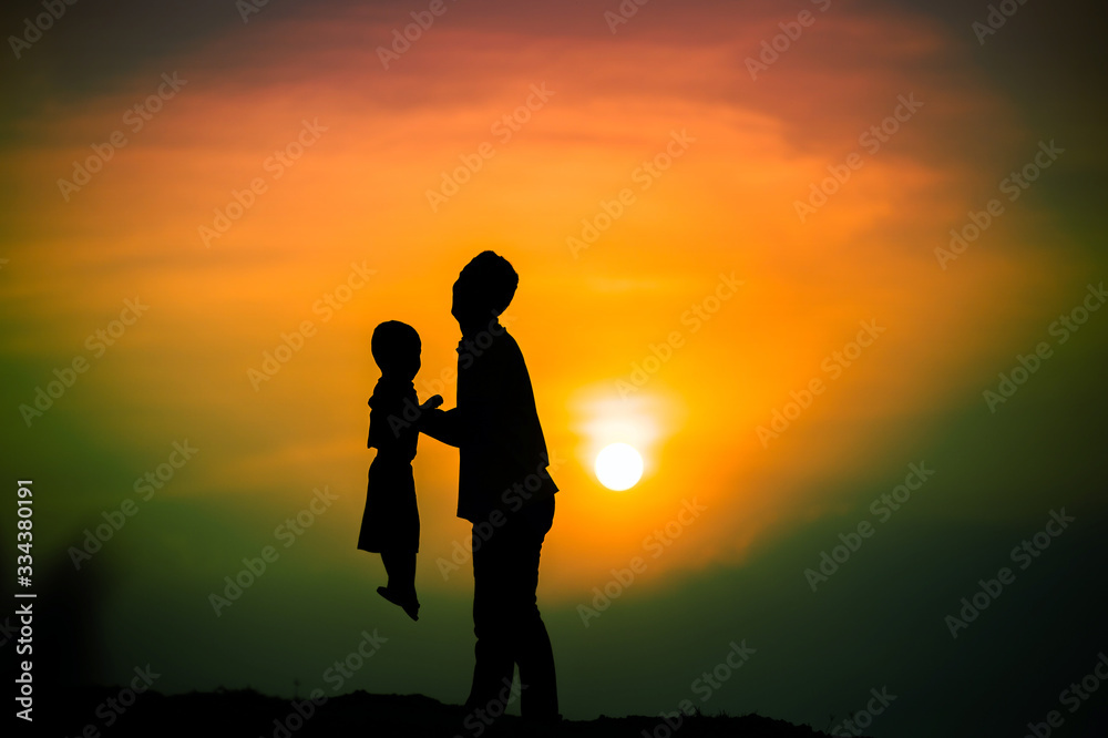 silhouette of the family that the father is playing with the boy happily with the sunset sky