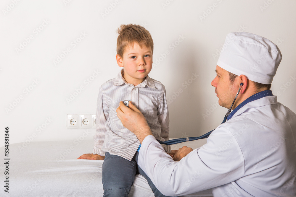 Obraz premium Man doctor and child patient. Male pediatrician with stethoscope listening to lung and heart sound of little boy