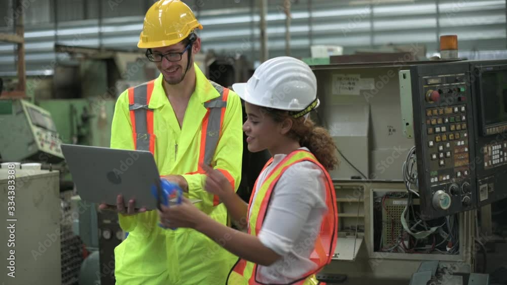 Caucasian man with laptop and mixed race woman engineer working in factory area. Caucasian man with laptop and mixed race woman engineer working in factory area.