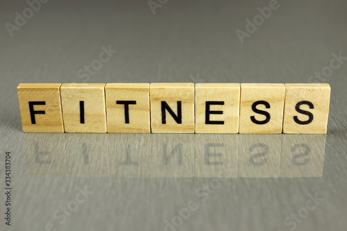 word fitness is made of square wooden letters on a gray background