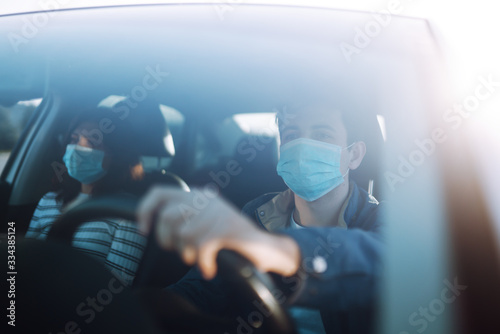 Boy and girl wear protective sterile medical mask in the car. The concept of preventing the spread of the epidemic and treating coronavirus, pandemic in quarantine city. Covid -19.