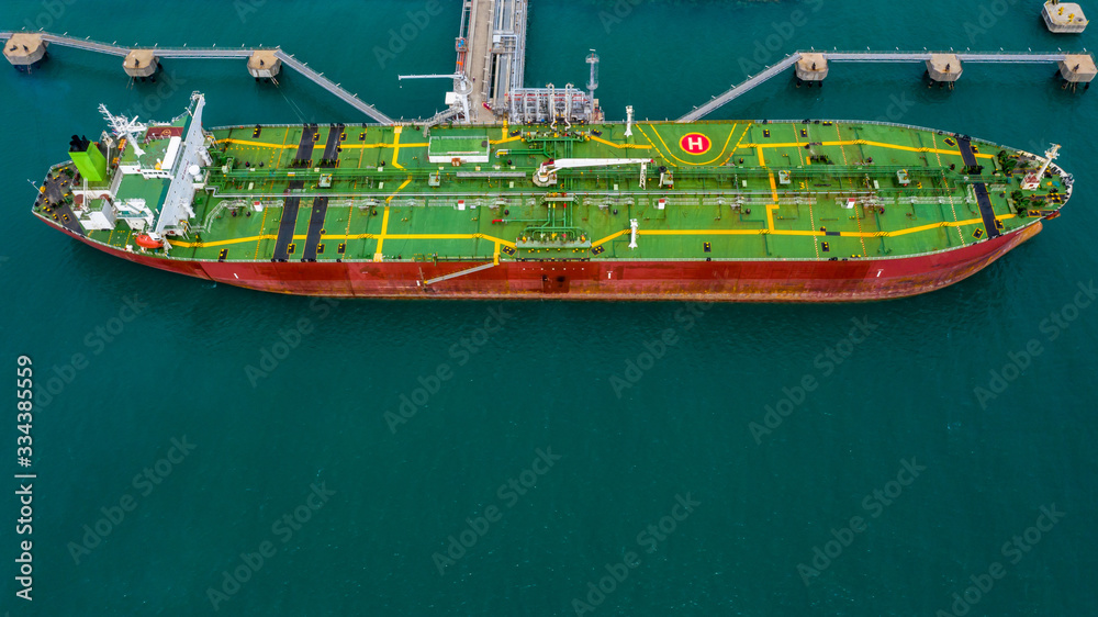 Aerial view tanker ship vessel unloading at port, Business import export oil and gas petrochemical tanker ship cargo transportation oil from dock refinery, Loading arm oil and gas offshore platform.