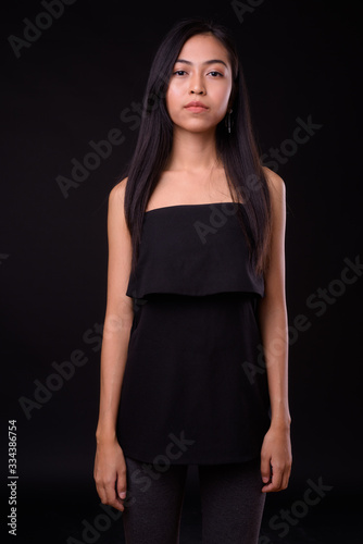 Portrait of young beautiful Asian woman looking at camera