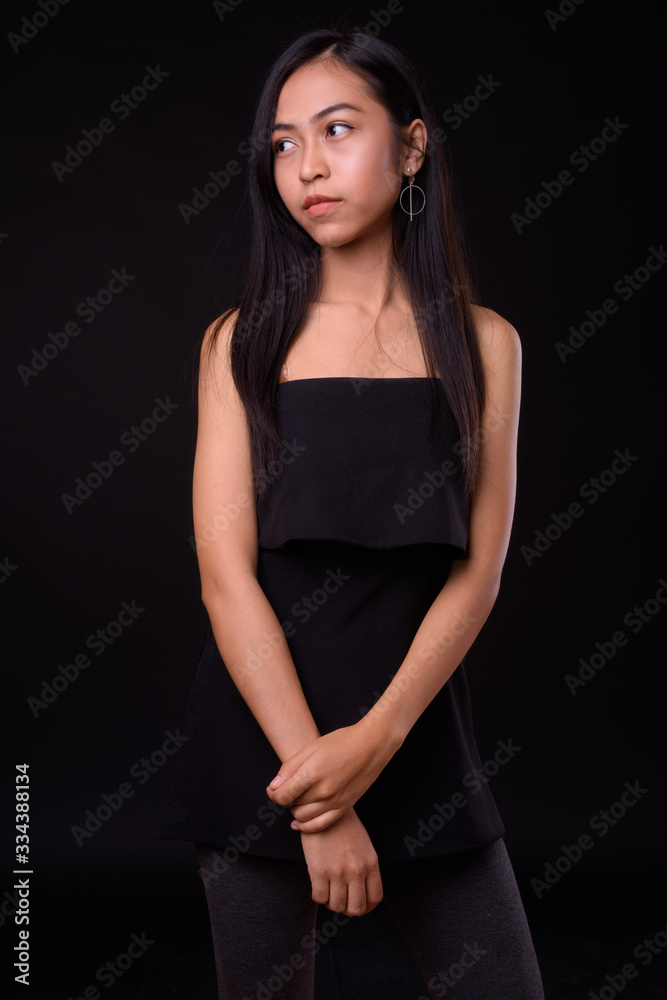 Portrait of young beautiful Asian woman thinking and looking away Portrait of young beautiful Asian woman thinking and looking away