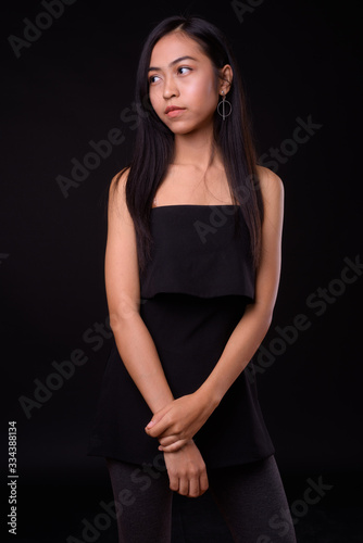 Portrait of young beautiful Asian woman thinking and looking away
