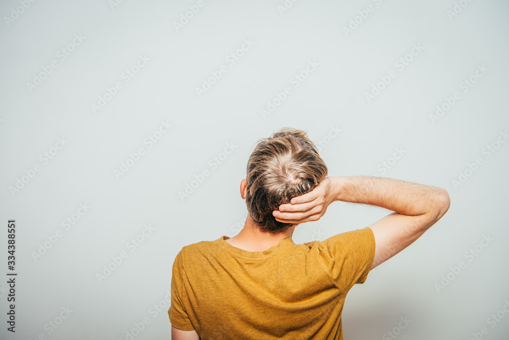 young man . Back view. On a gray background young man . Back view. On a gray background