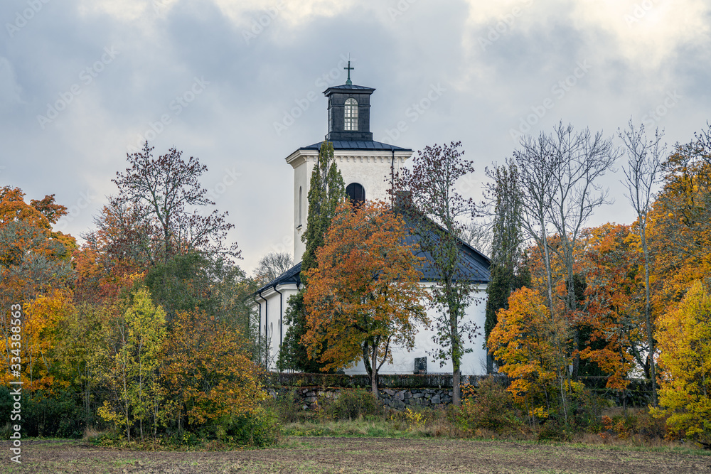 Obraz premium Beautiful church surrounded by autumn colored trees