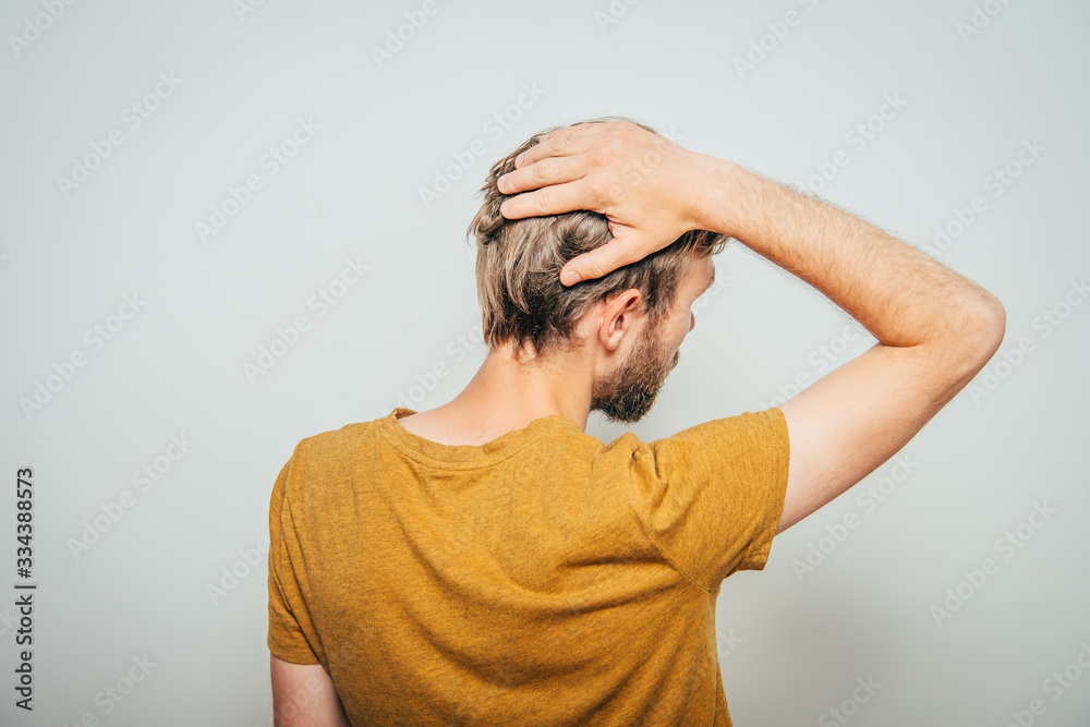 young man . Back view. On a gray background young man . Back view. On a gray background
