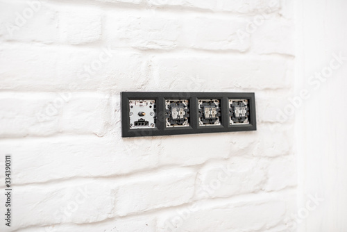Installing electric sockets and switches on the white brick wall