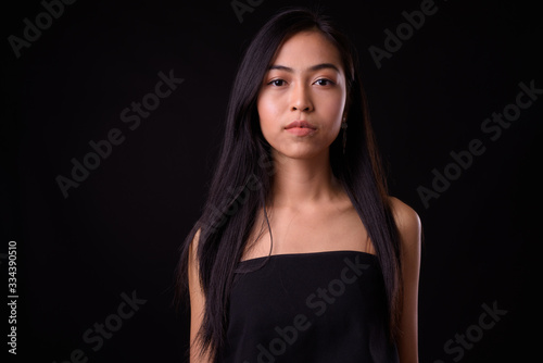 Face of young beautiful Asian woman looking at camera