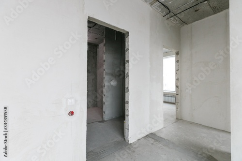 interior of a new apartment without finishing in gray tones with electrical wiring