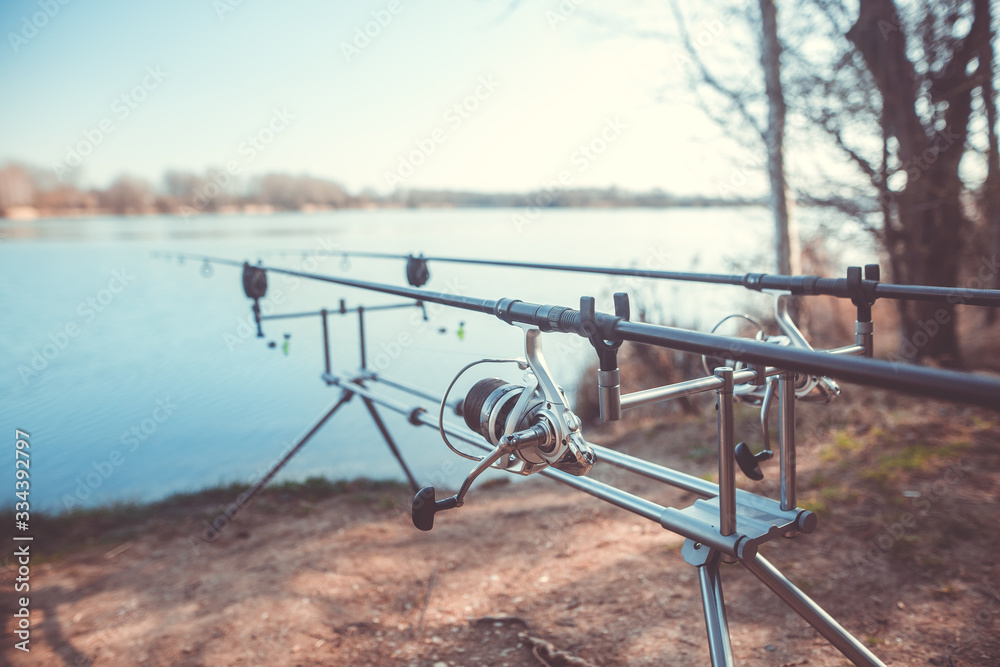 Two cast fishing rods on the rack by the lake, ready for fishing, carpfishing, angling, sport concept