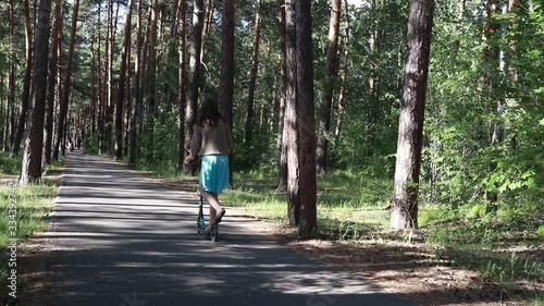 Wallpaper Mural girl riding a scooter in a park in a pine forest Torontodigital.ca