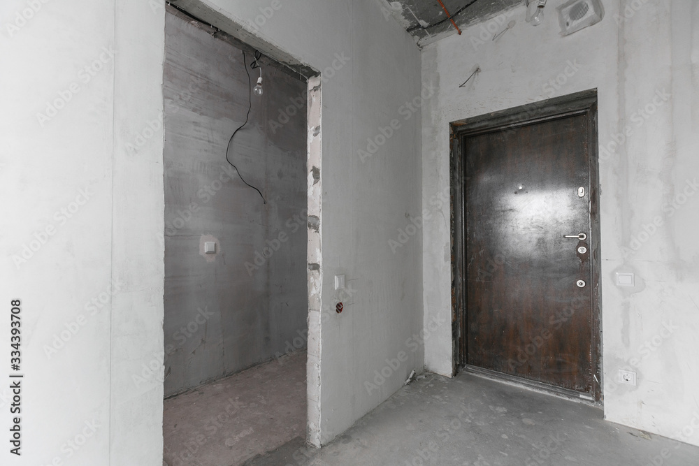 interior of a new apartment without finishing in gray tones with electrical wiring interior of a new apartment without finishing in gray tones with electrical wiring